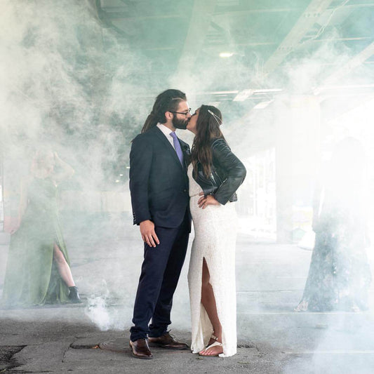 Wedding couple posing with soft colored smoke behind them