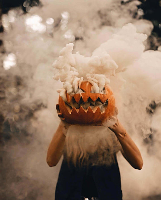 Pumpkin head photoshoot couple with colored smoke outdoors