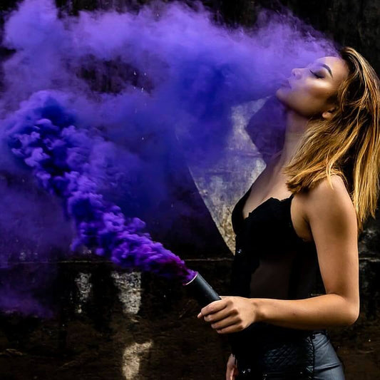 Photographer framing a model holding a colored smoke bomb