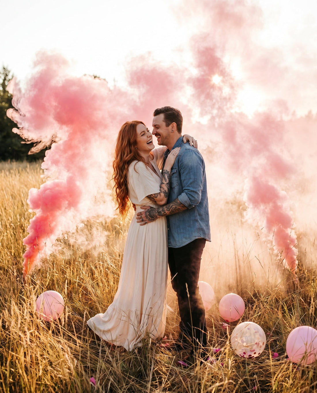 Pink smoke gender reveal in a grassy field at sunset